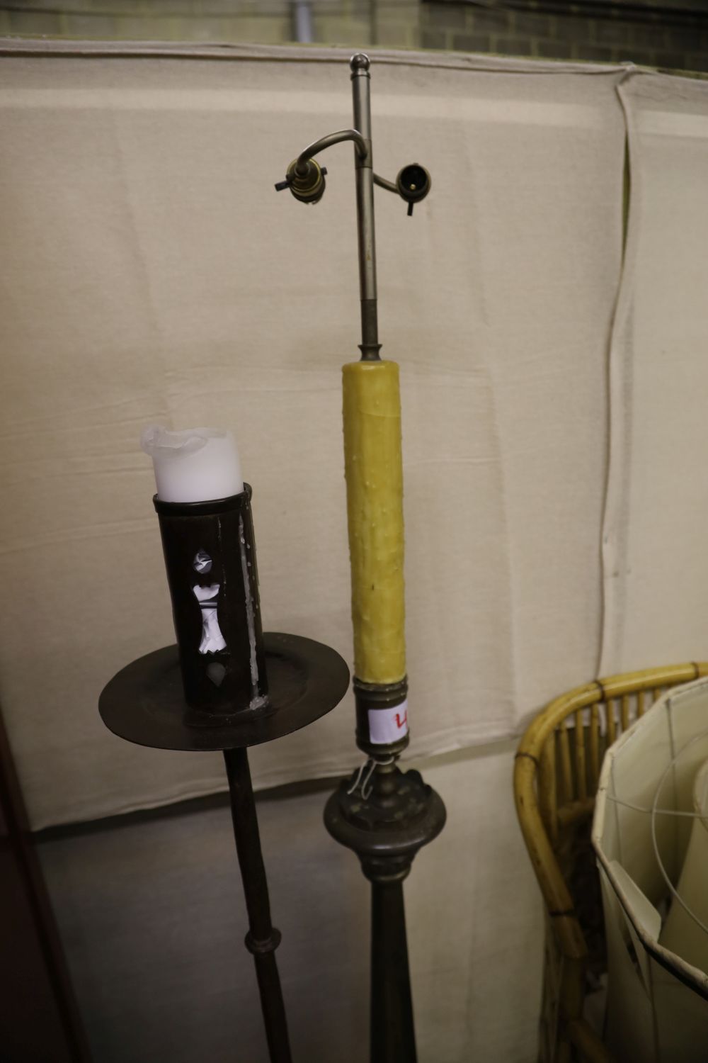 A wrought iron church style candlestand and a metal standard lamp and shade